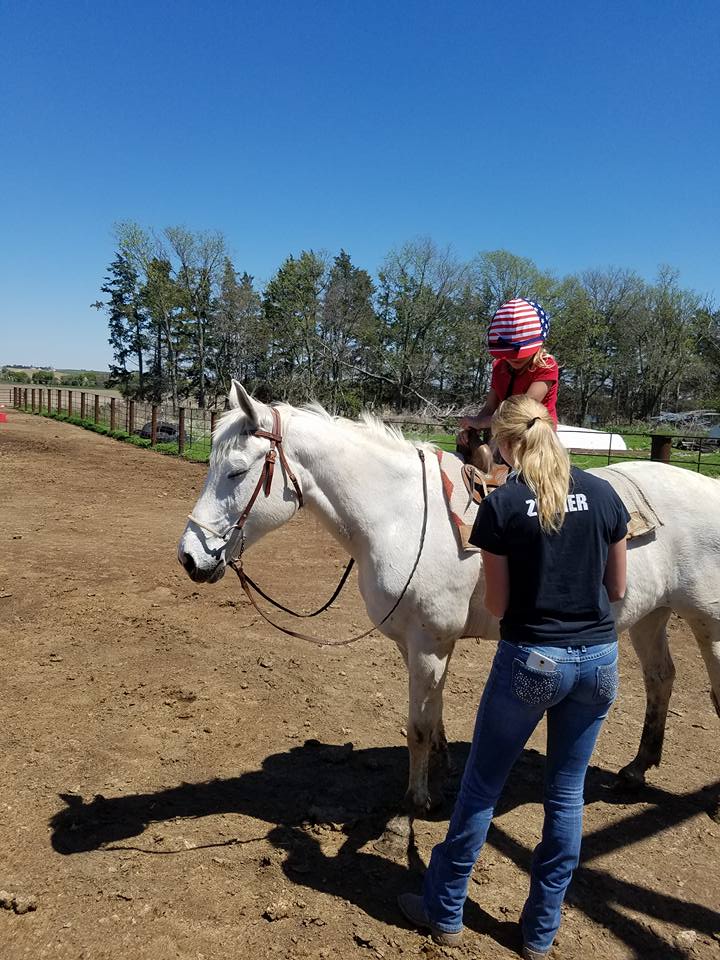 Bre teaching a girl on a horse
